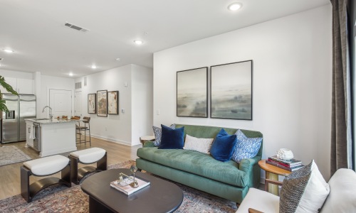 Living room with green couch and kitchen 